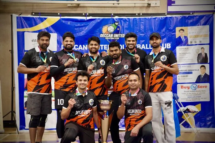 Deccan United team in black and orange jerseys with their medals